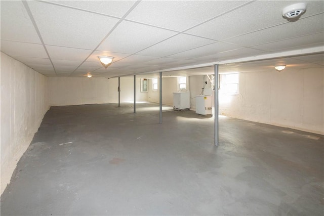 basement with a paneled ceiling and washer / clothes dryer