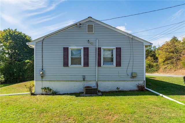 back of property with a yard and central air condition unit