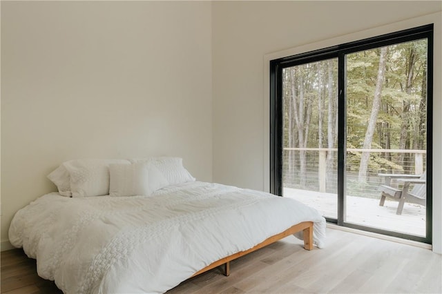 bedroom with wood-type flooring and access to outside