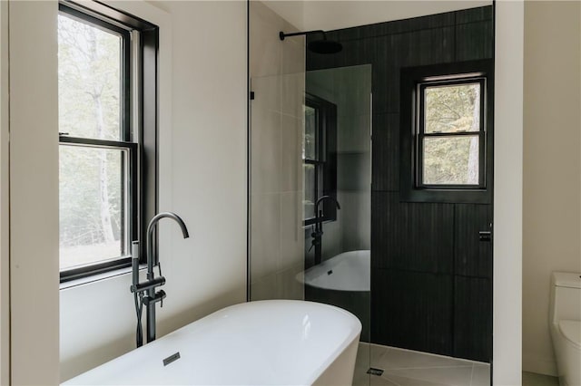 bathroom with tile patterned floors, a healthy amount of sunlight, toilet, and separate shower and tub