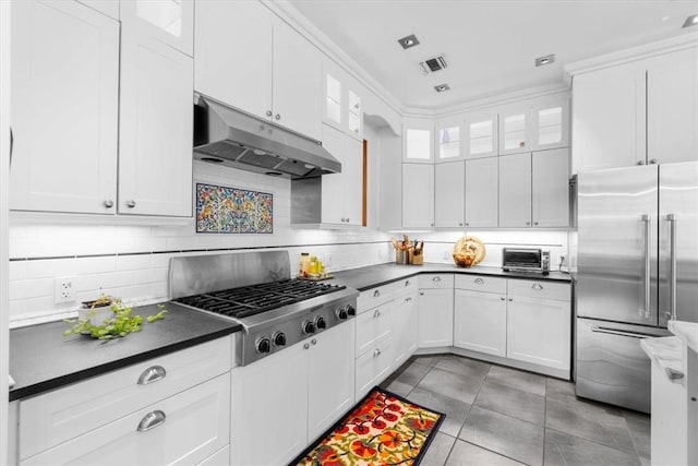 kitchen featuring white cabinetry, appliances with stainless steel finishes, light tile patterned flooring, and backsplash