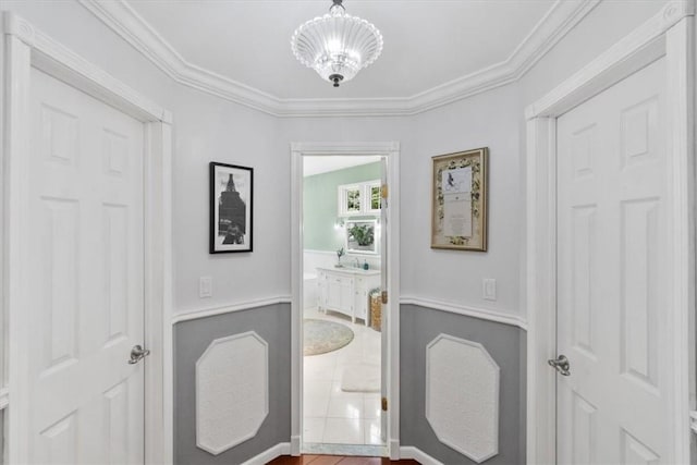 interior space with a notable chandelier, crown molding, and tile patterned floors