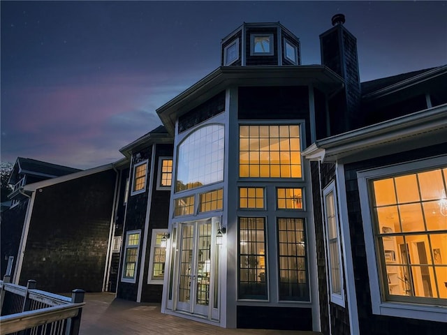 property exterior at dusk featuring french doors