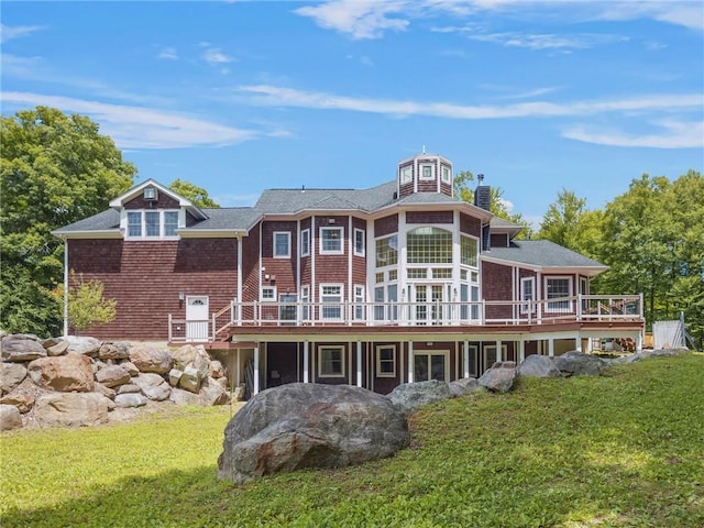 rear view of property with a deck and a lawn