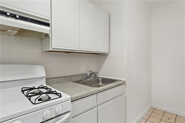 kitchen featuring white range with gas cooktop, sink, range hood, white cabinetry, and light tile patterned flooring