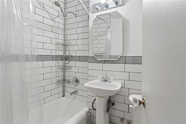 bathroom with toilet, tile walls, and shower / bath combo with shower curtain