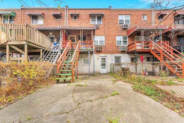 rear view of property with a wooden deck and cooling unit