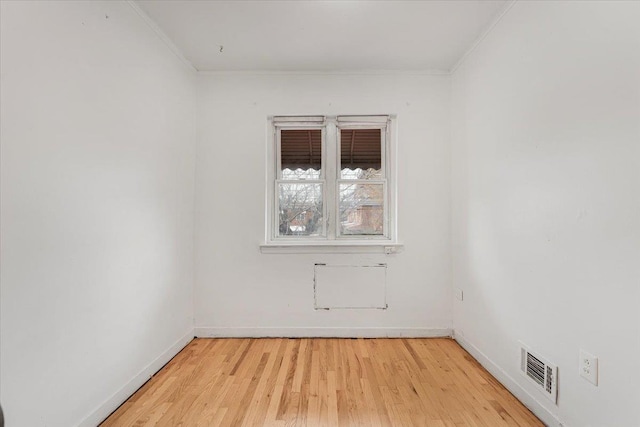 spare room with wood-type flooring and ornamental molding