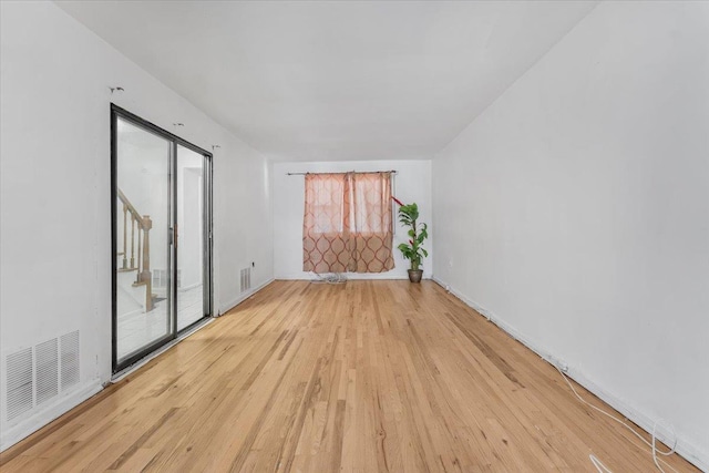 empty room featuring plenty of natural light and light hardwood / wood-style floors