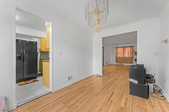 dining area with light wood-type flooring and an inviting chandelier