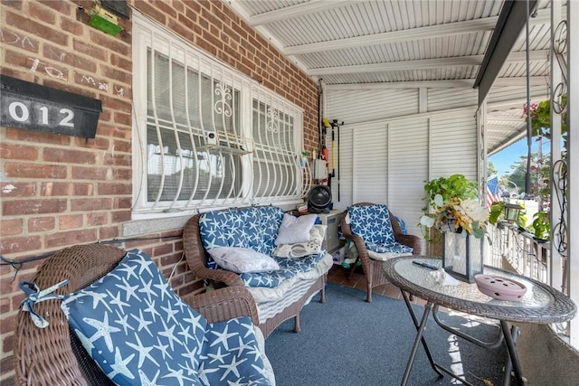 sunroom / solarium featuring vaulted ceiling with beams