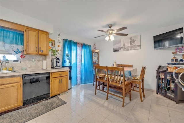 kitchen featuring ceiling fan, a healthy amount of sunlight, black dishwasher, and tasteful backsplash