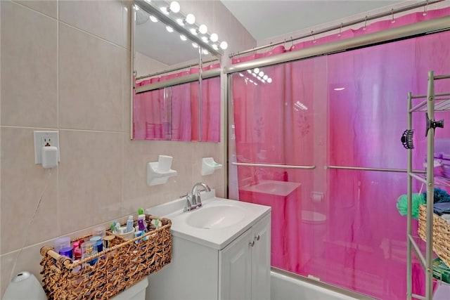 bathroom featuring vanity, tile walls, and washtub / shower combination