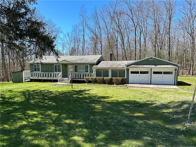 ranch-style house featuring a front lawn, covered porch, and a garage