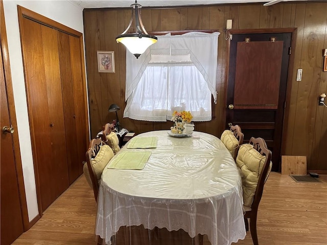 dining space featuring wood walls and light hardwood / wood-style floors