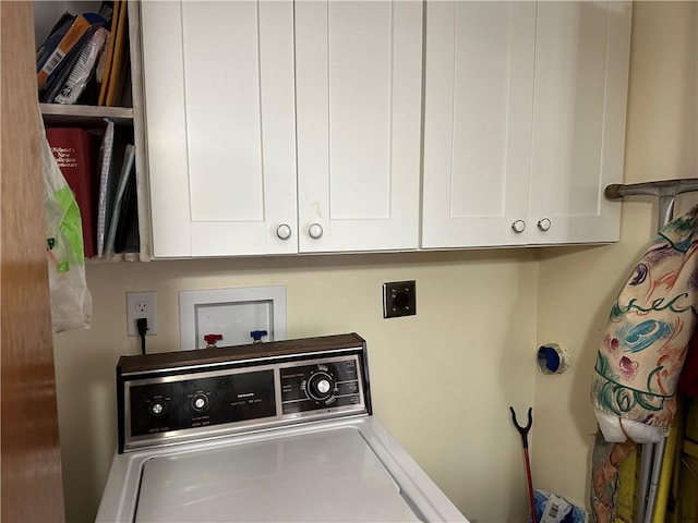 clothes washing area featuring cabinets and washer / dryer