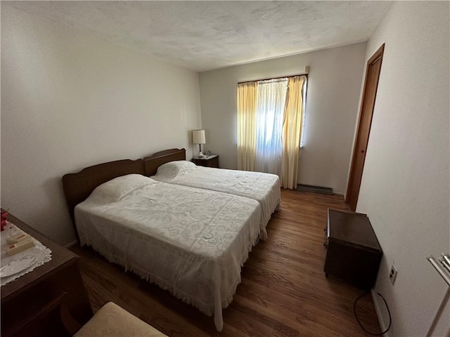 bedroom featuring a textured ceiling and dark wood-type flooring