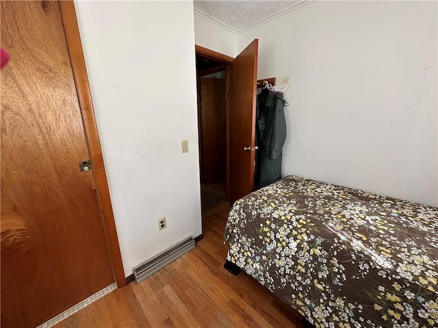 bedroom featuring hardwood / wood-style floors and crown molding