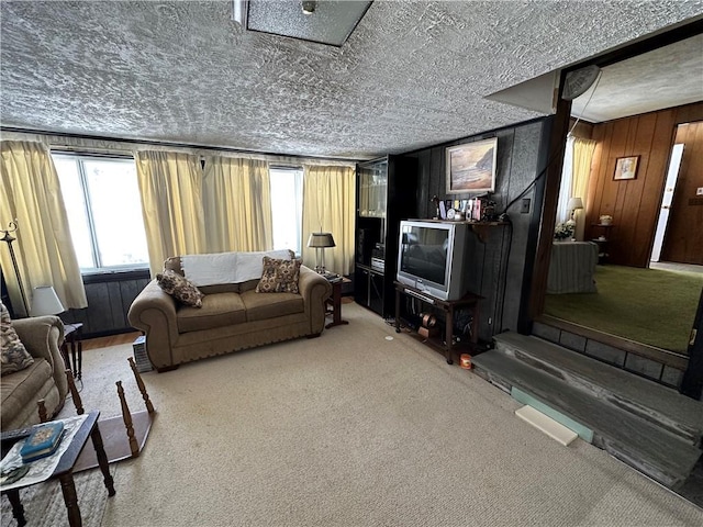 carpeted living room with wooden walls and a textured ceiling