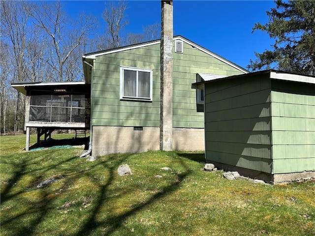 view of home's exterior with a lawn and a sunroom