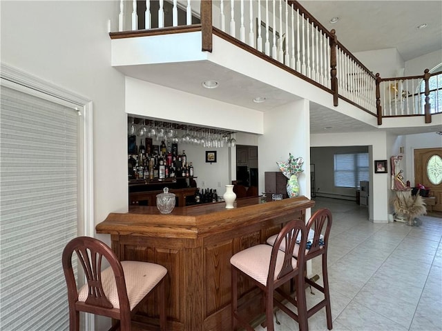 bar with a towering ceiling and light tile patterned floors