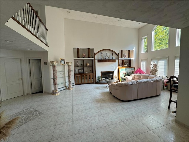 living room with light tile patterned floors and a towering ceiling