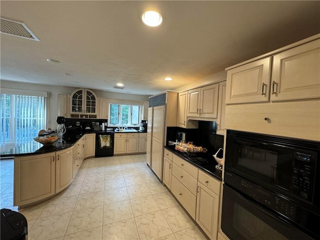 kitchen with backsplash, black appliances, and cream cabinetry