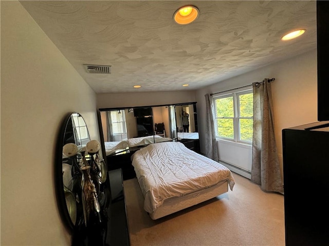 bedroom with vaulted ceiling, a textured ceiling, and a baseboard heating unit