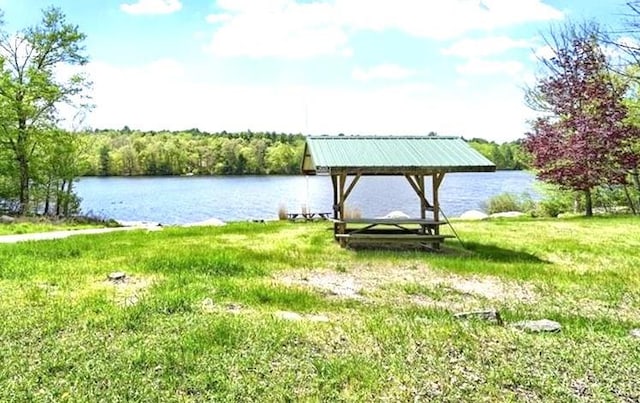 view of dock featuring a gazebo, a yard, and a water view