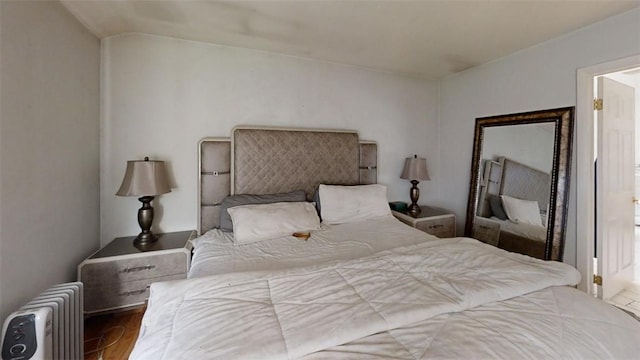 bedroom featuring hardwood / wood-style floors and radiator heating unit