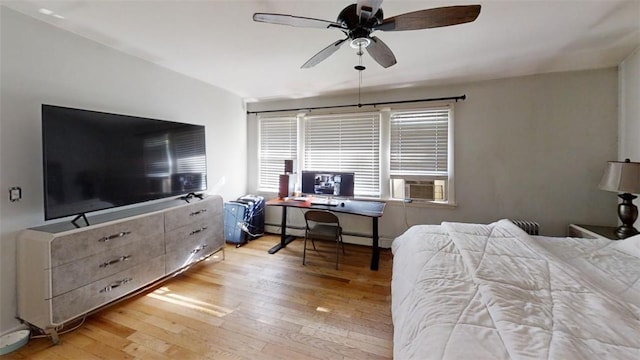 bedroom featuring a baseboard heating unit, light hardwood / wood-style floors, ceiling fan, and cooling unit