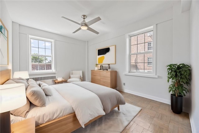 bedroom featuring ceiling fan, radiator heating unit, and parquet floors