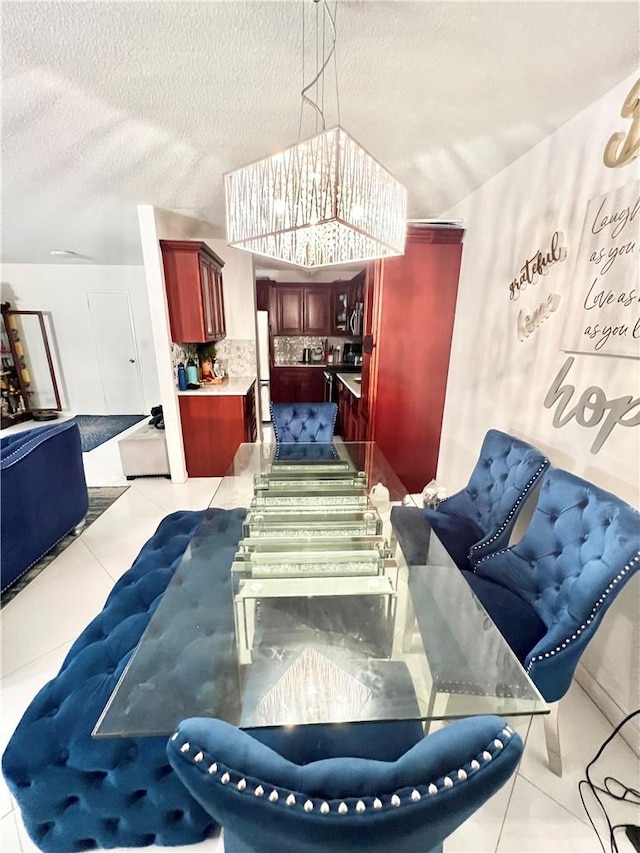 tiled dining space with a notable chandelier and a textured ceiling