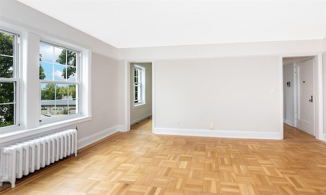 spare room with light parquet flooring and radiator