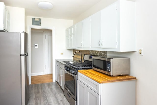 kitchen with white cabinetry, sink, light hardwood / wood-style flooring, and appliances with stainless steel finishes