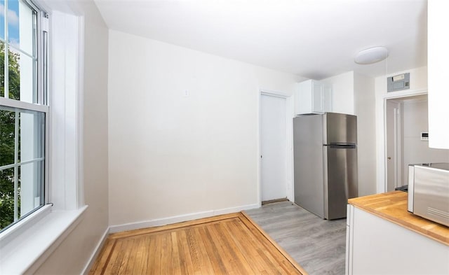 kitchen with a healthy amount of sunlight, stainless steel refrigerator, and light hardwood / wood-style flooring