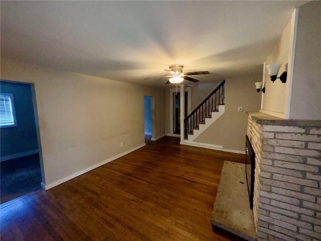 unfurnished living room with dark hardwood / wood-style floors, ceiling fan, and a fireplace