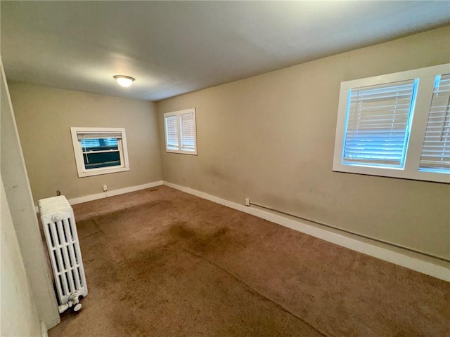 spare room with carpet floors and radiator