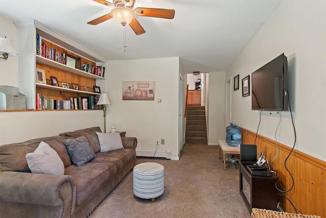 living room featuring ceiling fan, wood walls, carpet, and a baseboard heating unit