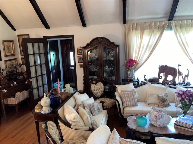 living room featuring beamed ceiling and wood-type flooring