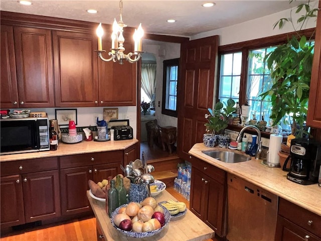 kitchen with sink, stainless steel dishwasher, a chandelier, decorative light fixtures, and light hardwood / wood-style floors