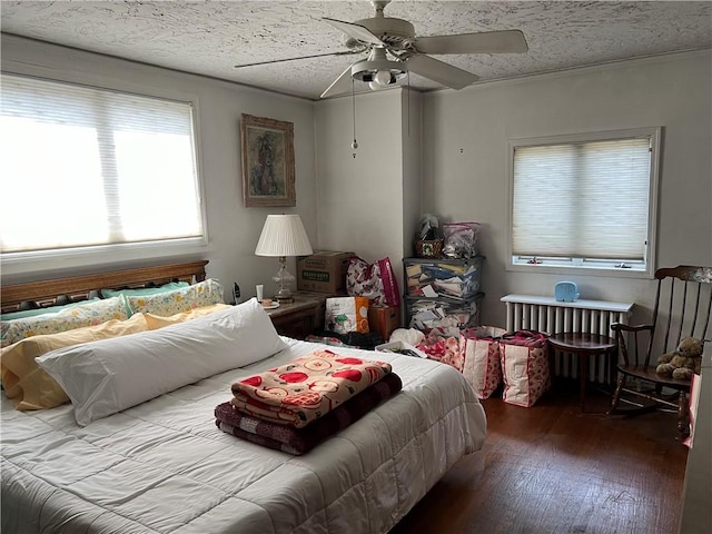 bedroom with radiator, a textured ceiling, hardwood / wood-style flooring, and ceiling fan