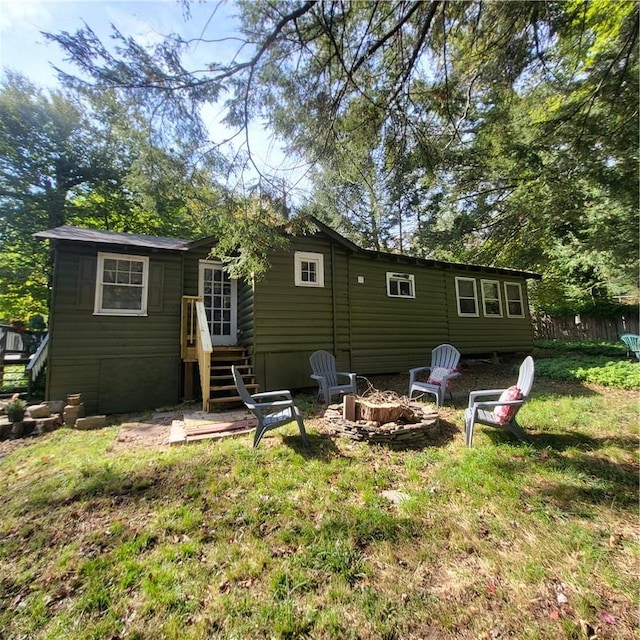 rear view of property with an outdoor fire pit