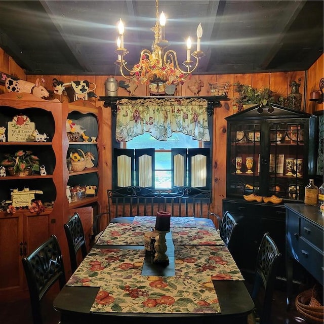 dining room featuring wooden walls and a chandelier