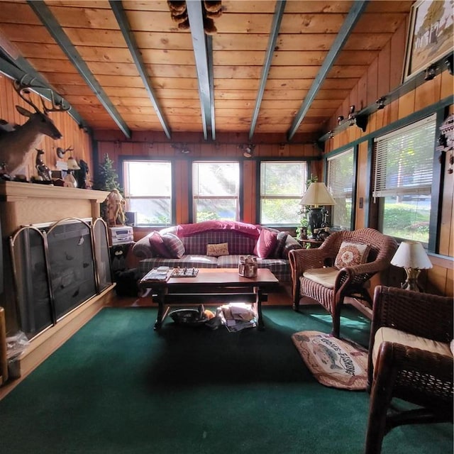 living room with carpet floors, vaulted ceiling with beams, wooden ceiling, and wooden walls