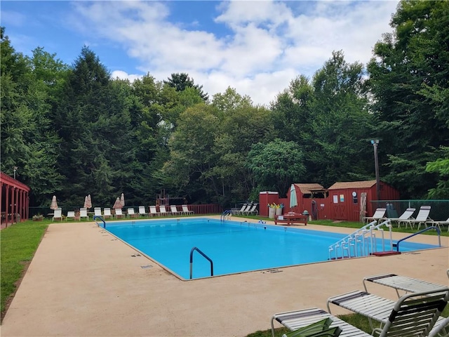 view of pool featuring an outbuilding and a patio area