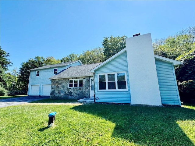 view of front of property with a garage and a front lawn