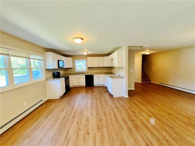 kitchen featuring a baseboard heating unit, white cabinetry, a healthy amount of sunlight, and black appliances