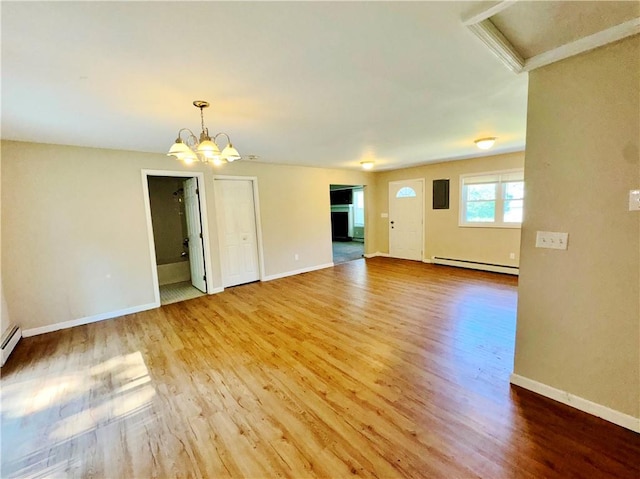 unfurnished living room with hardwood / wood-style floors, an inviting chandelier, and a baseboard heating unit