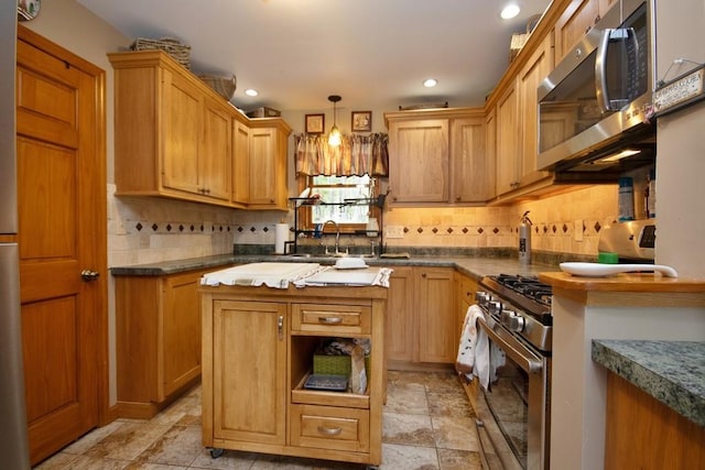 kitchen with backsplash, sink, decorative light fixtures, and appliances with stainless steel finishes